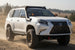 Lifted white Lexus GX460 with AEGON roof rack, snorkel and exterior MOLLE panel on a dirt trail