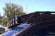 Sleek low-profile aluminum roof rack for GMC Sierra with integrated wind deflectors to reduce wind noise and drag.